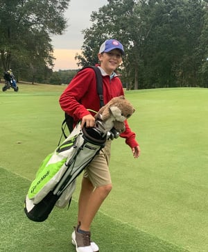 Carter Waggoner, Player Development Member, carries clubs on the course – Greystone