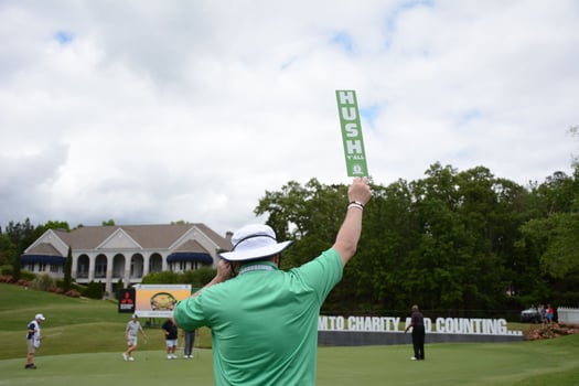 A man holding a hush sign at the 2021 Regions Tournament at Greystone