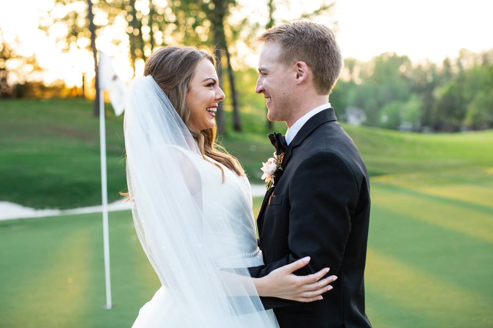 the satterfields on the green at greystone, embracing on their wedding day