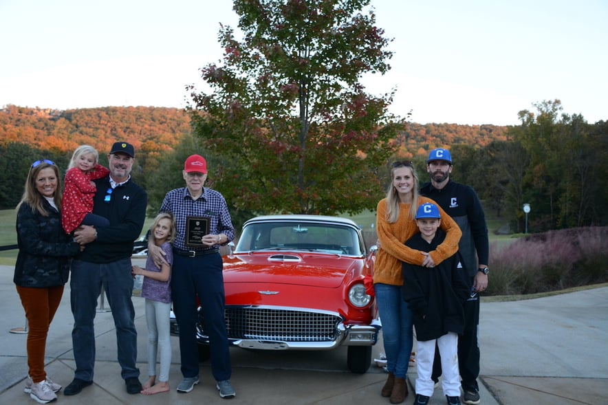 four generations of a family standing next to a red vintage car